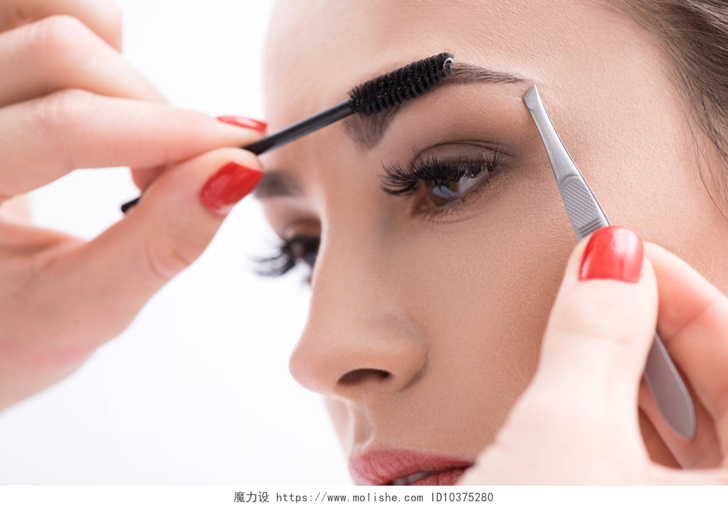 一个美丽的女人对着镜子在画眉毛年轻女子钳她的眉毛在美容院